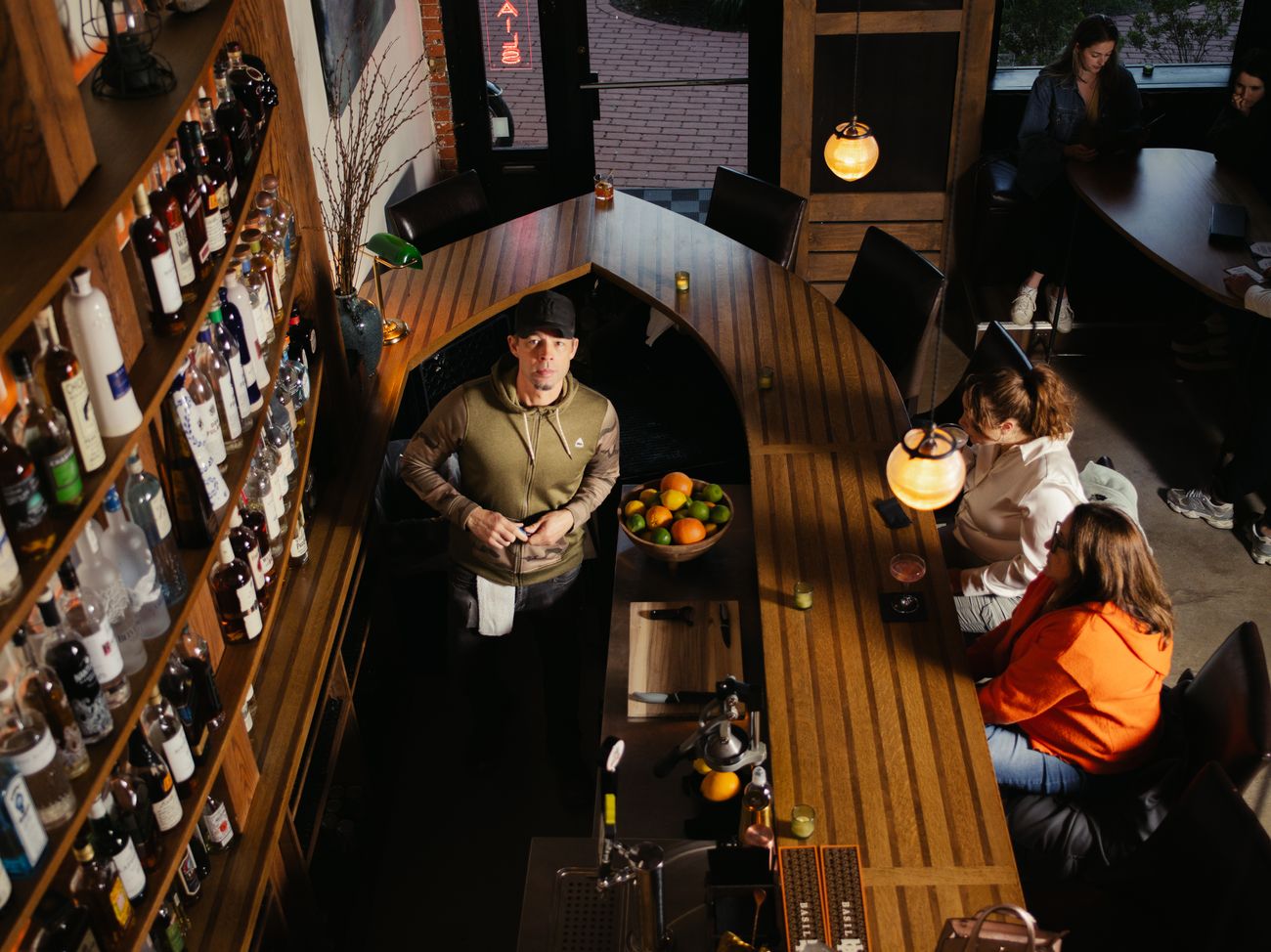 Overhead view of the bartender at work behind the bar with guests.