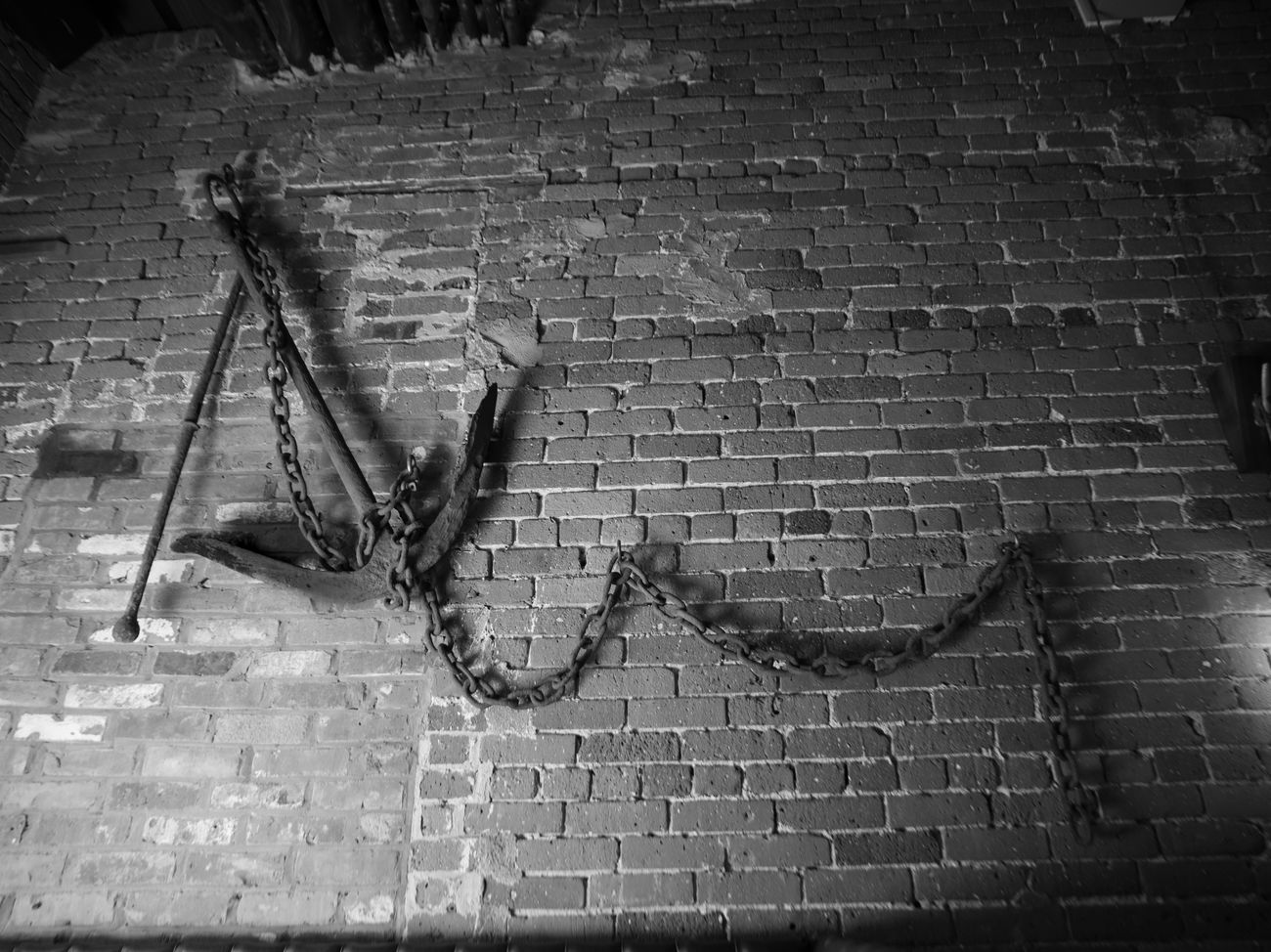 A ship's anchor mounted on the exposed brick wall.