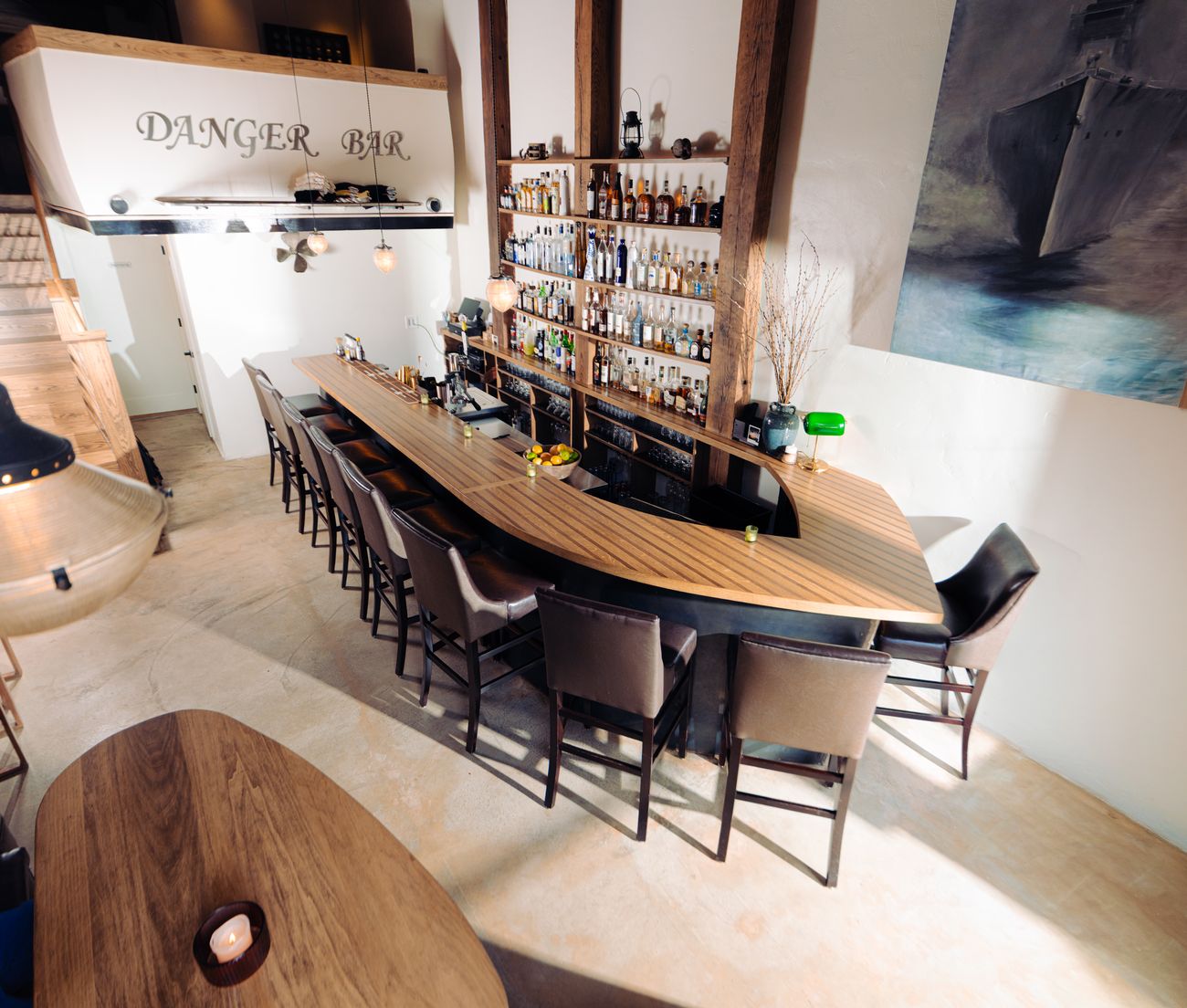 The empty bar counter and stools set and ready under the Danger Bar sign.