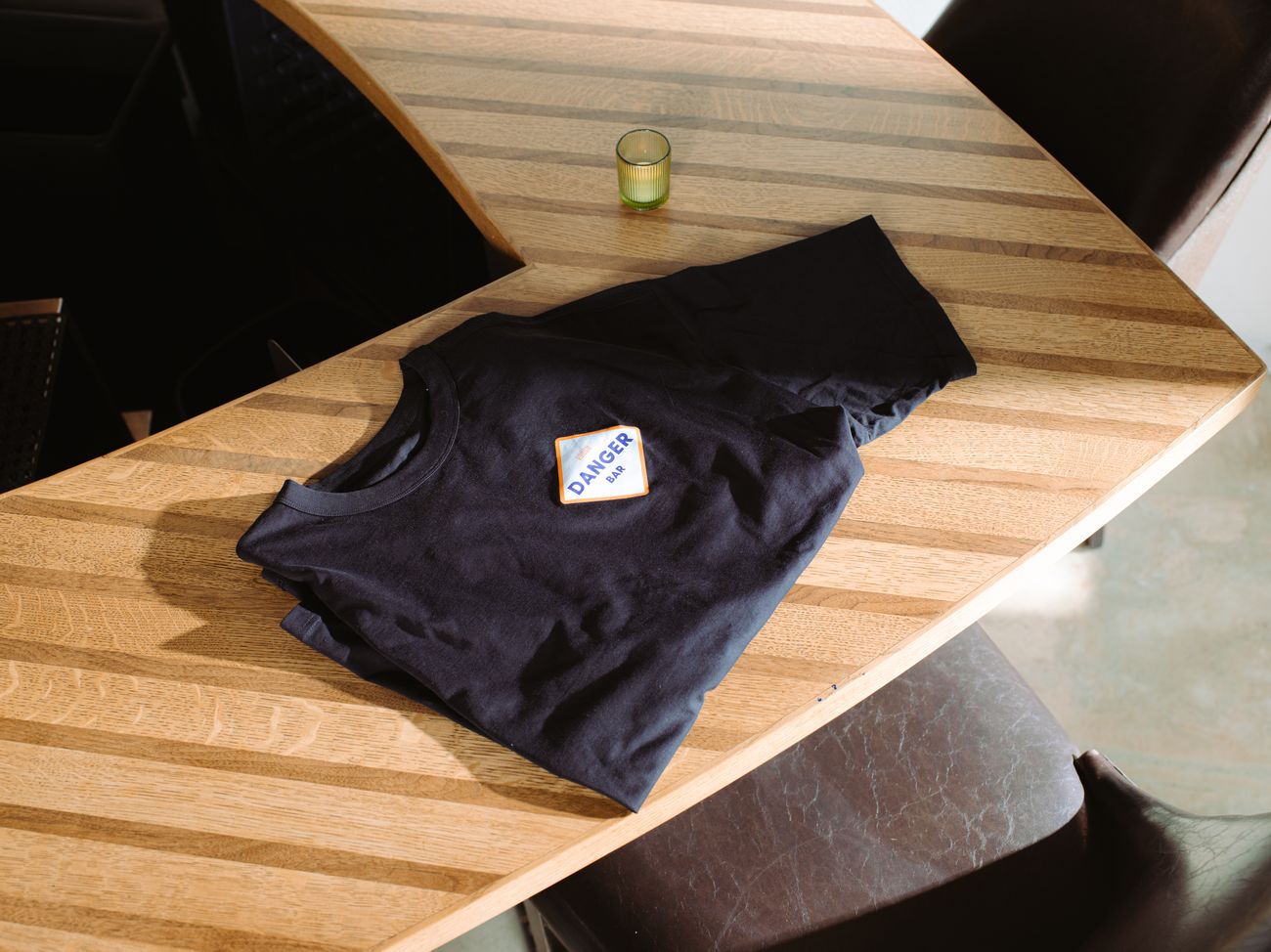 A Danger Bar t-shirt laid out on the wooden bar.
