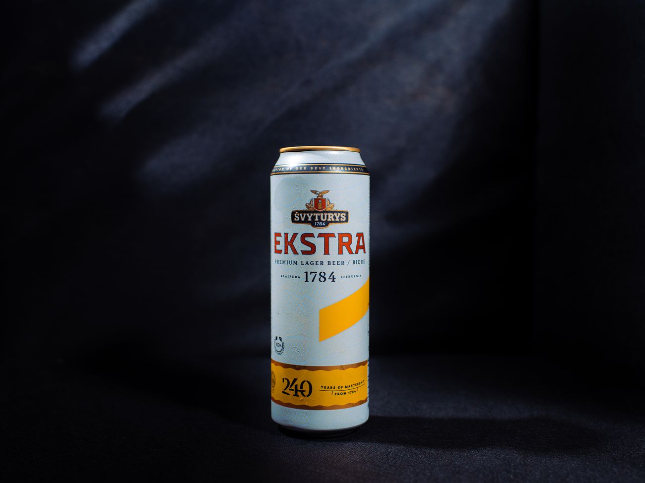 A can of Svyturys Ekstra lager, dramatically lit on a dark background.